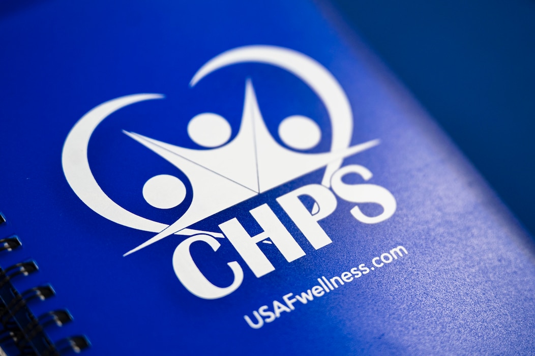 A blue notebook with a logo and "CHPS" "USAFwellness.com" is pictured.