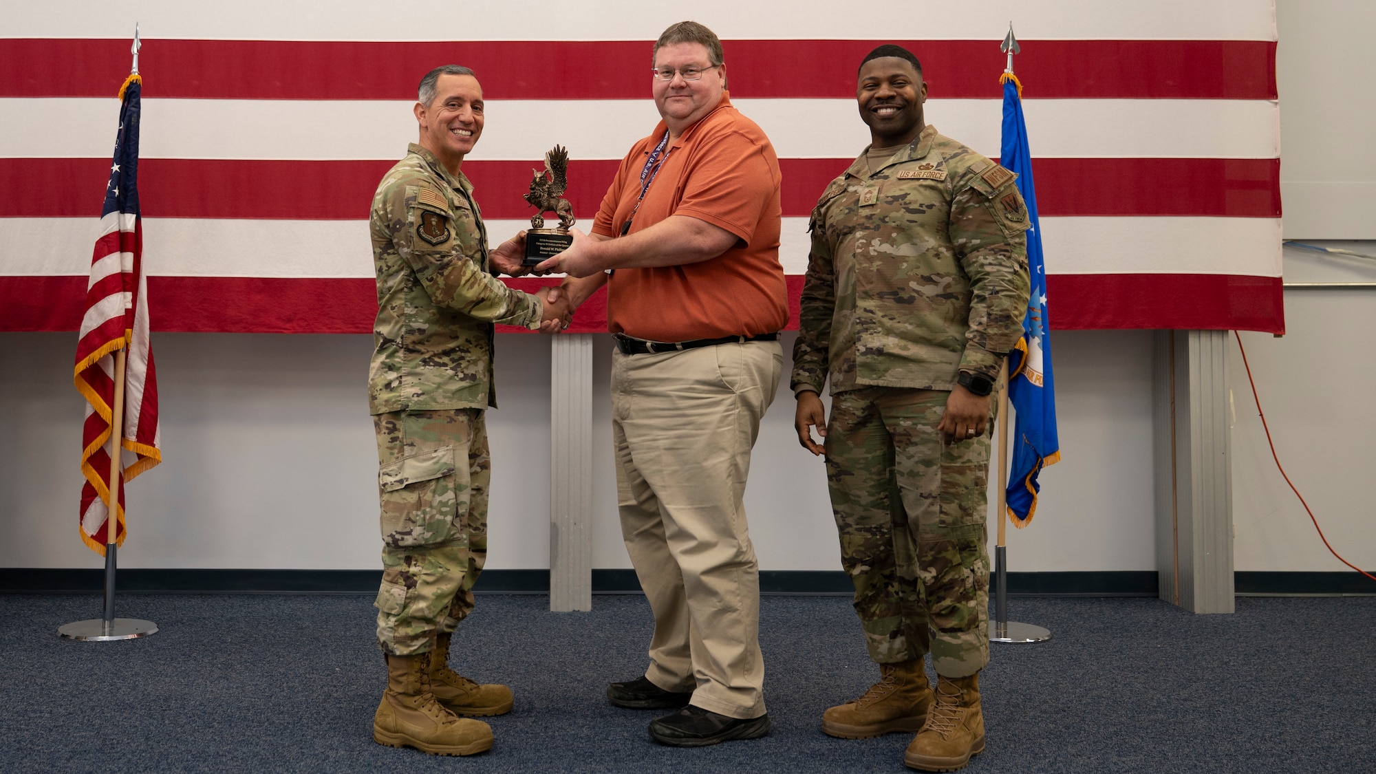 Airmen pose for a group photo with award
