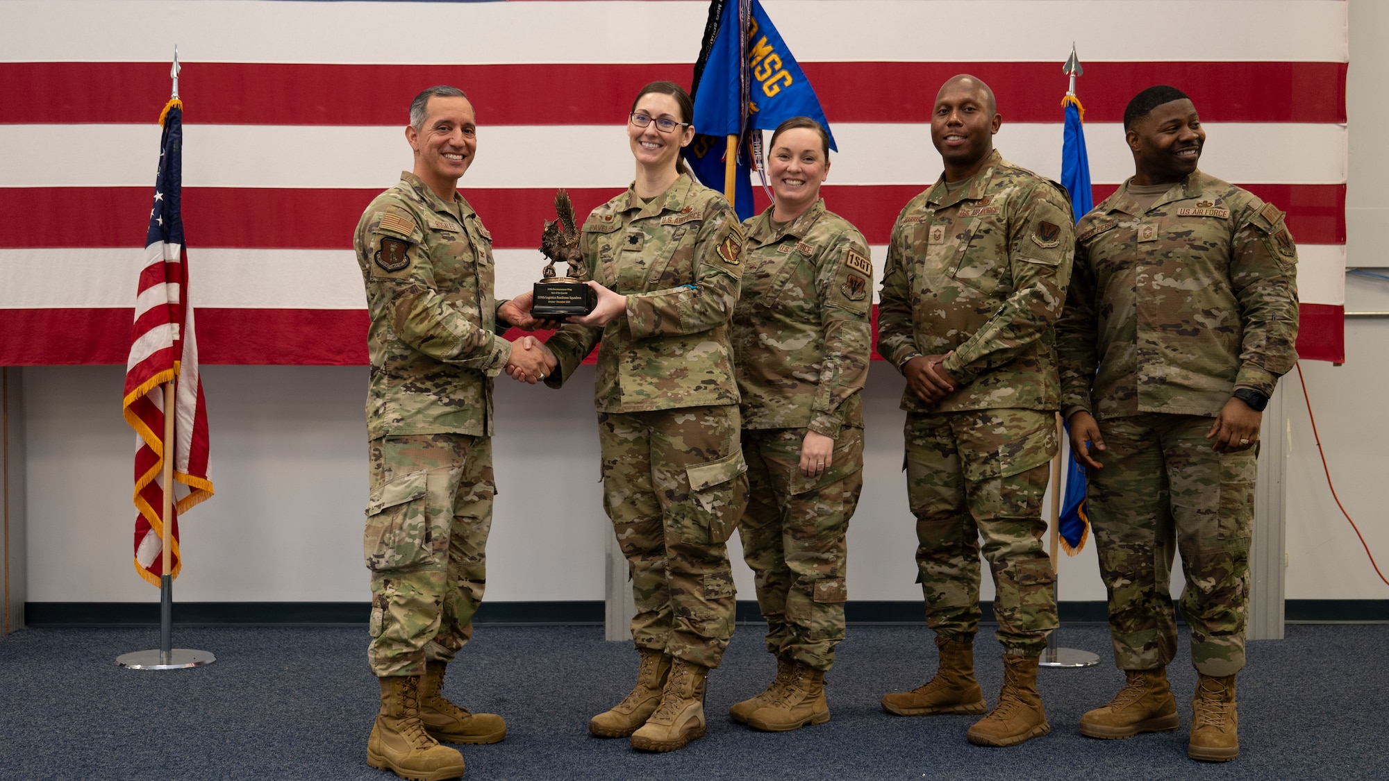 Airmen pose for a group photo with award