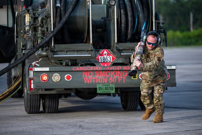 Air Force Tech Sgt. Daniel Lemons, assigned to the 110th Expeditionary Bomb Squadron, pulls out a fuel hose during a hot pit refuel on a B-2 Spirit stealth bomber during a Bomber Task Force mission at Diego Garcia, British Indian Ocean Territory in 2024.