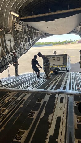 Airmen from the 48th Aerial Port Squadron and the 735th Air Mobility Squadron load cargo onto an aircraft at Joint Base Pearl Harbor-Hickam, Hawaii, Nov. 13, 2025.