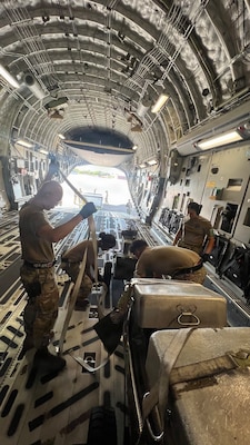 Airmen from the 48th Aerial Port Squadron and the 735th Air Mobility Squadron reposition cargo inside an aircraft at Joint Base Pearl Harbor-Hickam, Hawaii, Nov. 13, 2025.