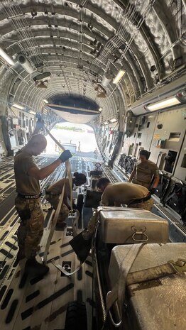Airmen from the 48th Aerial Port Squadron and the 735th Air Mobility Squadron reposition cargo inside an aircraft at Joint Base Pearl Harbor-Hickam, Hawaii, Nov. 13, 2025.