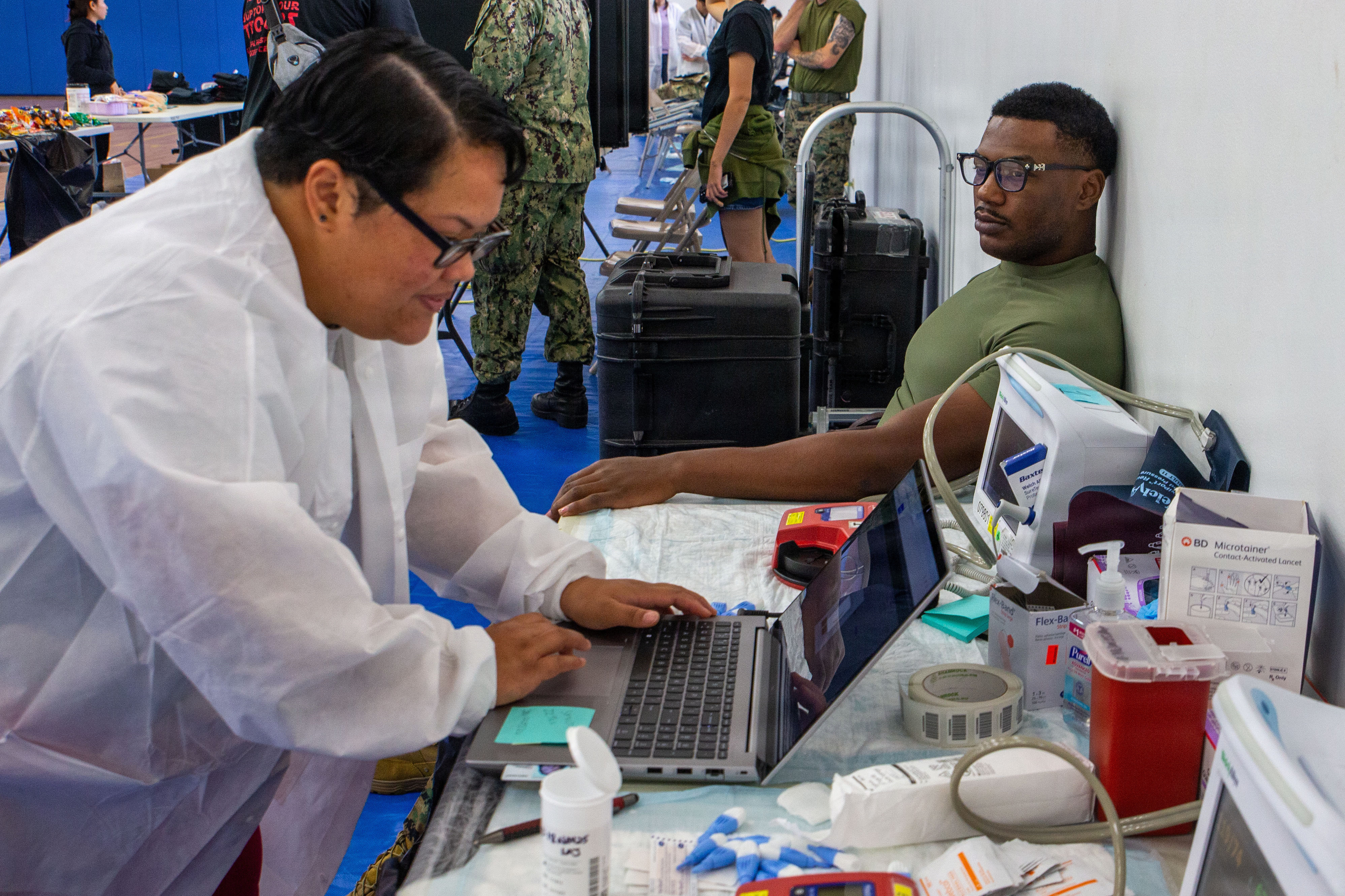 U.S. Navy Reservist Larrisha Cruz, phlebotomist and administrative assistant, checks vitals of U.S. Marine Corps Sgt. Kendell Jones, personnel noncomissioned officer in charge, Headquarters Company, Marine Corps Base Camp Blaz, during a blood drive on MCB Camp Blaz, Guam, Jan. 27, 2026. Camp Blaz partnered with Armed Services Blood Program Donor Center Guam and Naval Hospital Guam to help host blood drives. This is the first blood drive of 2026 and the third overall that Camp Blaz has hosted. (U.S. Marine Corps photo by Lance Cpl. Afton Smiley)