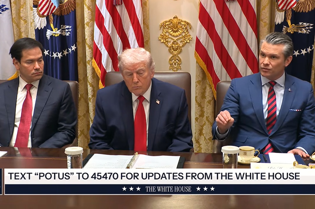 Three men sit near one another at a table. Behind them are U.S. and other flags. Text at the bottom of the image says "Text 'POTUS' to 45470 for updates from the White House."