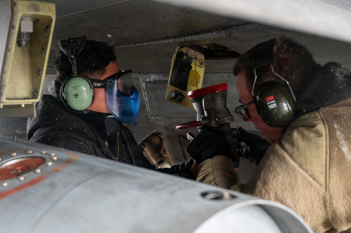 U.S. Air Force Senior Airman Joseph Masga, left, 14th Fighter Generation Squadron assistant dedicated crew chief, and Airman 1st Class Cameron Hall, 35th Logistics Readiness Squadron fuels distribution operator, connect a pantograph to an F-16 Fighting Falcon at Misawa Air Base, Japan, Jan. 15, 2026.