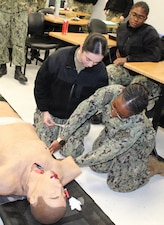 PATUXENT RIVER, Md. – (January 28, 2026) – U.S. Navy Hospital Corpsman 2nd Class Ja'Laia Lackey, from Naval Air Station Patuxent River's Search and Rescue (SAR) team, instructs Hospitalman Apprentice Kaitlyn Lewis, from the Military Readiness Clinic at Navy Medicine Readiness and Training Command Patuxent River, on locating the intercostal space on a training mannequin. The hands-on instruction was part of the Respiration Module of a Warrior Wednesday Lunch and Learn training, designed to enhance the life-saving skills of medical personnel.