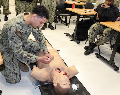 PATUXENT RIVER, Md – (January 28, 2026) – U.S. Navy Hospital Corpsman 3rd Class Miguel Rodriguez, assigned to the Medical Readiness Clinic at Navy Medicine Readiness and Training Command Patuxent River practices performing a needle chest decompression on a training mannequin during the Respiration Module of a Warrior Wednesday Lunch and Learn training. This hands-on training allows Sailors to build and maintain proficiency in critical, life-saving medical interventions for battlefield emergencies.