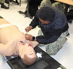 PATUXENT RIVER, Md. – (January 28, 2026) – U.S. Navy Hospitalman Lakadyia Roberts, from Medical Home Port at Naval Branch Health Clinic Patuxent River, practices a needle chest decompression on a training mannequin during the Respiration Module of a Warrior Wednesday Lunch and Learn training. This recurring training ensures medical personnel are prepared to provide critical care in operational environments, reinforcing the skills necessary to save lives.