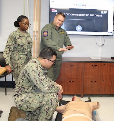 PATUXENT RIVER, Md. – (January 28, 2026) – U.S. Navy Chief Hospital Corpsman Mackenzie Gordon, from Naval Air Station Patuxent River's Search and Rescue team, explains the physiological effects of massive chest hemorrhaging to Hospitalman Andrew Flores, from the Patuxent River Medical Home Port Clinic. The training, observed by Hospital Corpsman 2nd Class Ja'Lia Lackey (left), was part of a "Warrior Wednesday" Lunch and Learn session focused on advanced life-saving interventions for medical personnel.