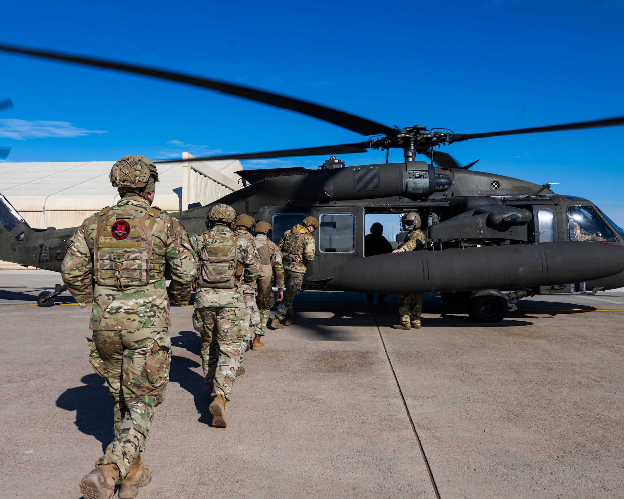 U.S. Airmen approach a UH-60 Black Hawk helicopter