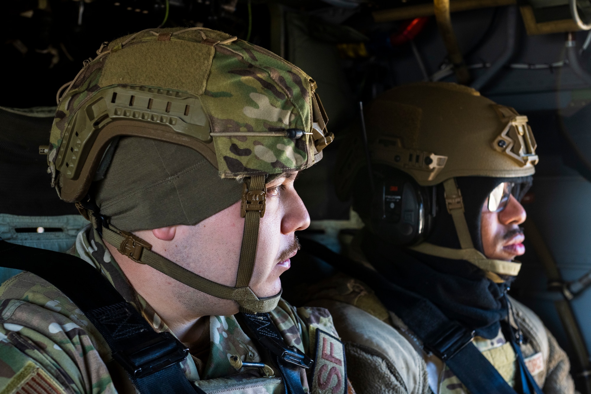 U.S. Airmen sit aboard a UH-60 Black Hawk helicopter