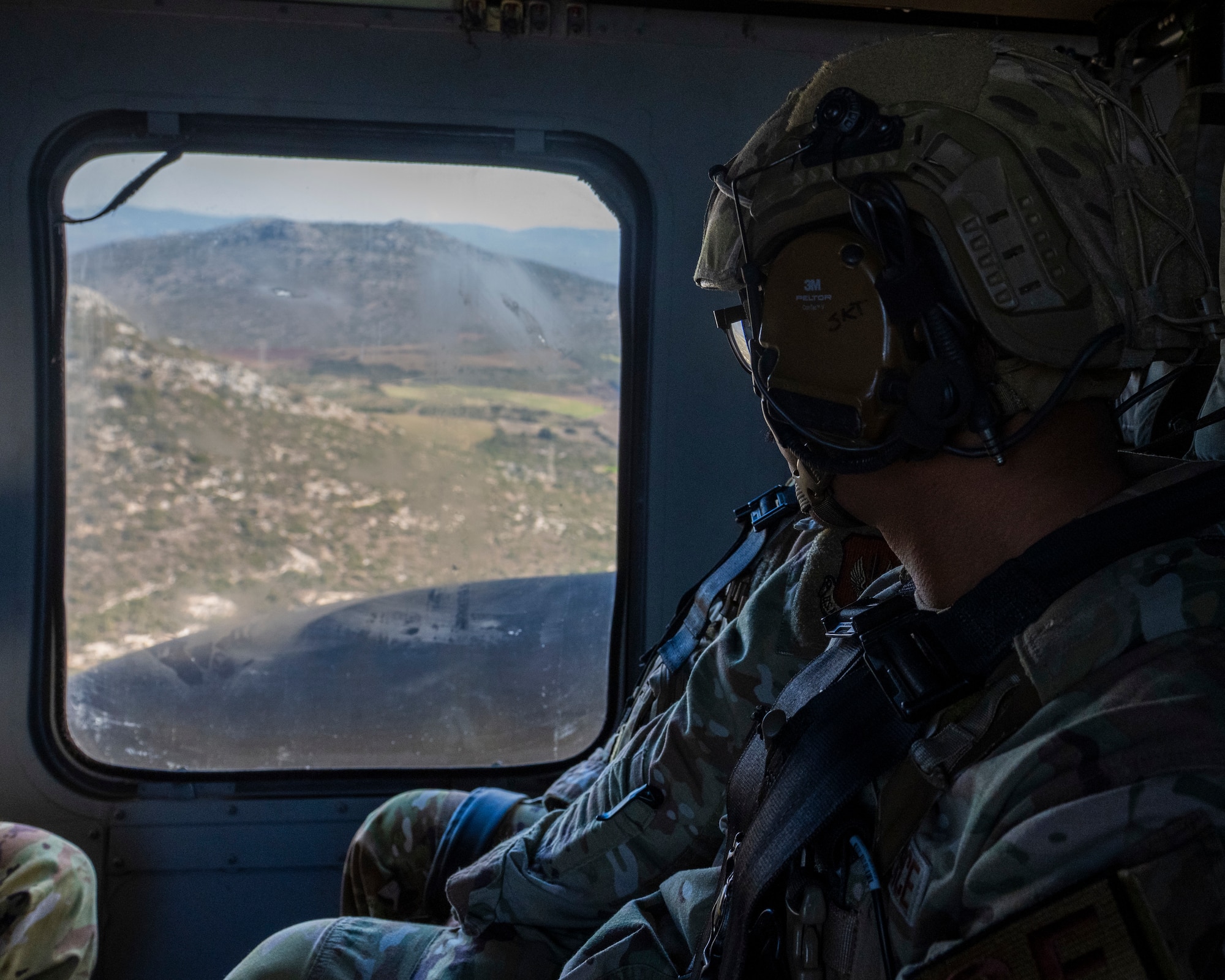 A U.S. Airman looks out from a UH-60 Black Hawk helicopter