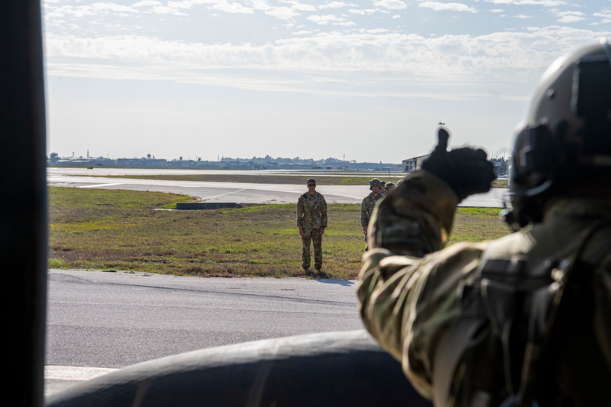 A U.S. Army Soldier signals to U.S. Airmen from a UH-60 Black Hawk helicopter