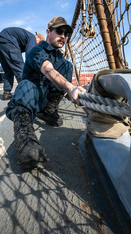 U.S. Navy Gunner’s Mate Seaman Brian Rhoades secures a mooring line on the flight deck of Arleigh Burke-class guided-missile destroyer USS Mitscher (DDG 57), Jan. 27, 2025. Mitscher is deployed to the U.S. 5th Fleet area of operations to support maritime security and stability in the U.S. Central Command area of responsibility.