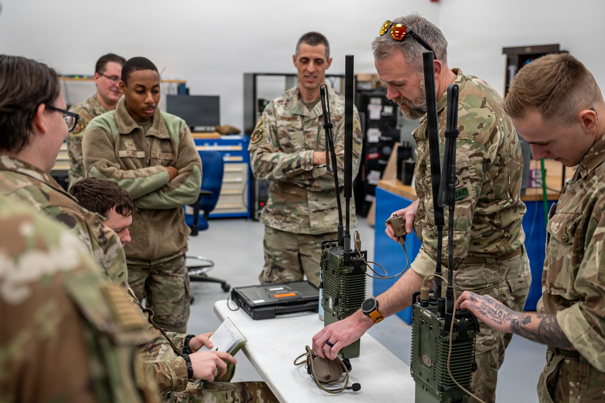 U.S. Air Force Airmen assigned to the 820th Base Defense Group and British Armed Forces members discuss radio equipment at Moody Air Force Base, Georgia, Jan. 15, 2026. U.S. and U.K. service members shared operational techniques and radio capabilities to improve communications in any environment and situation. (U.S. Air Force photo by Senior Airman Leonid Soubbotine)