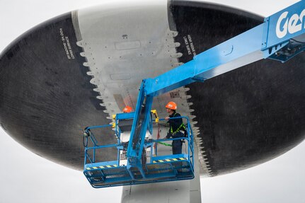 Airman inspecting the radar dome of an E-3