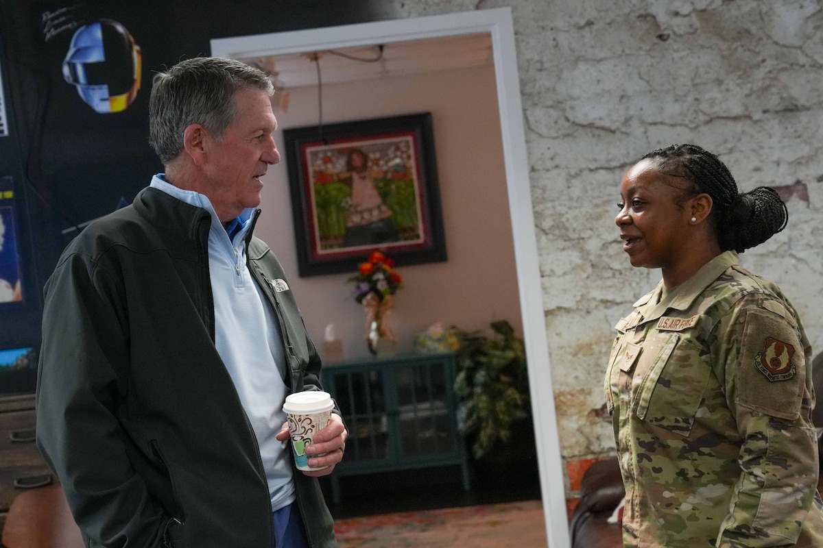 Photo shows two people speaking to one another.