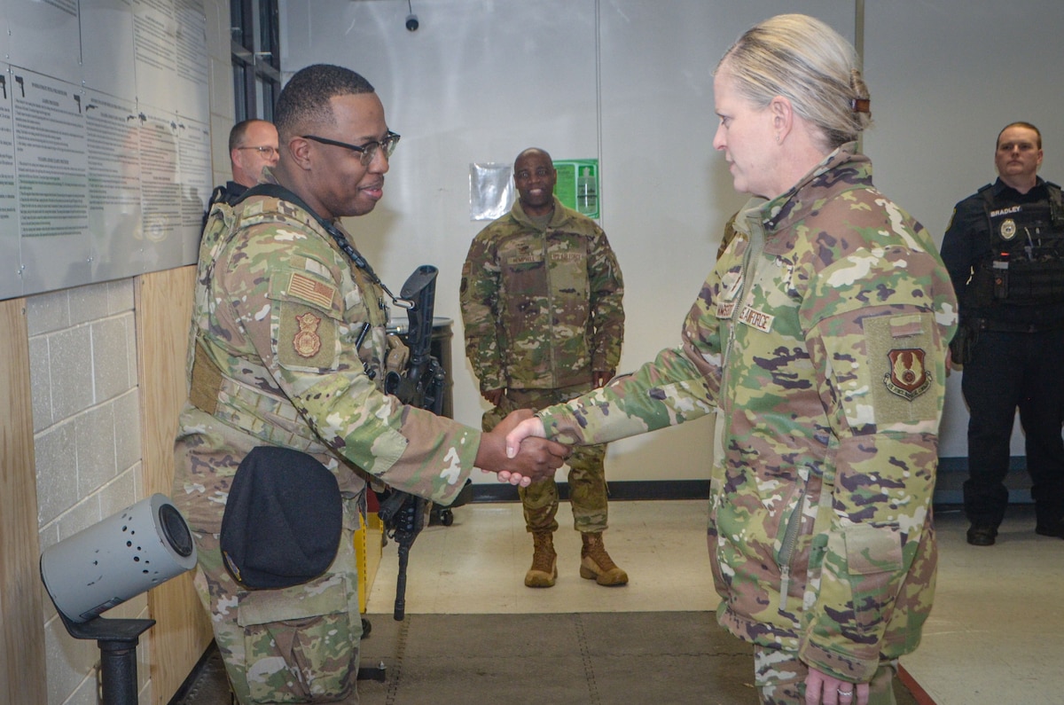 Video shows two people in uniform shaking hands.