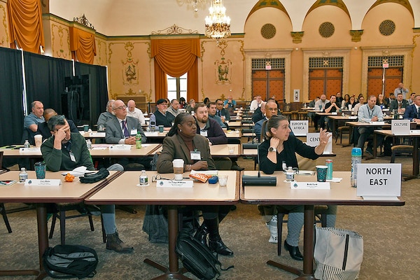 People seated at tables in a large room.
