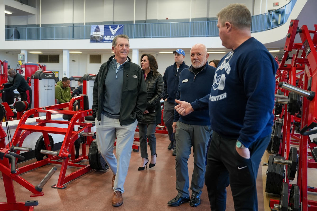 Photo shows group of people walking between fitness equipment.