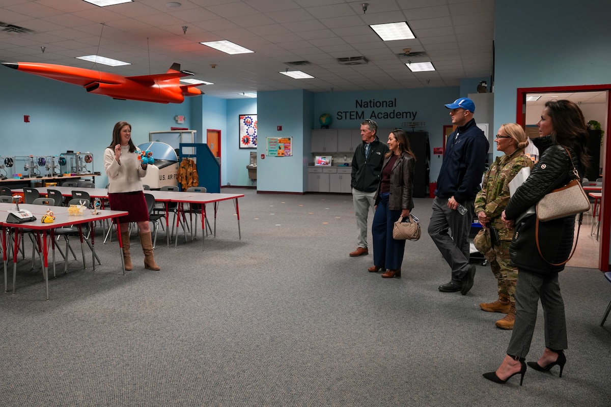 Photo shows group of people standing in classroom