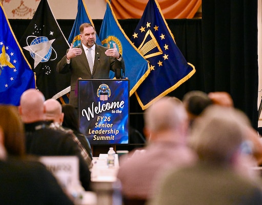 A man stands behind a podium and speaks