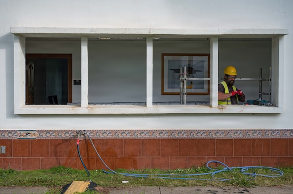 A Spanish contractor is in a white windowsill drilling.