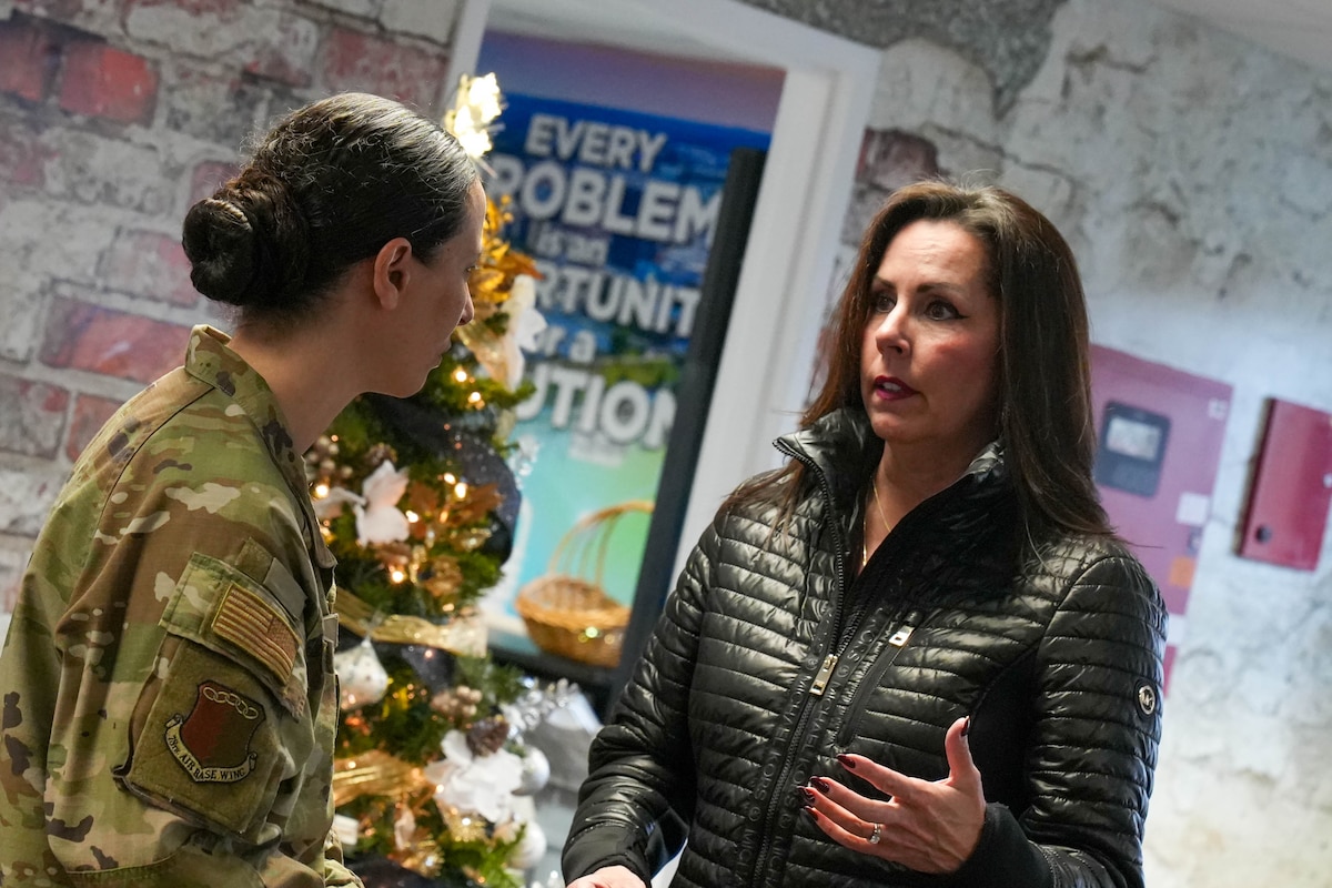 Photo shows two people speaking to one another.