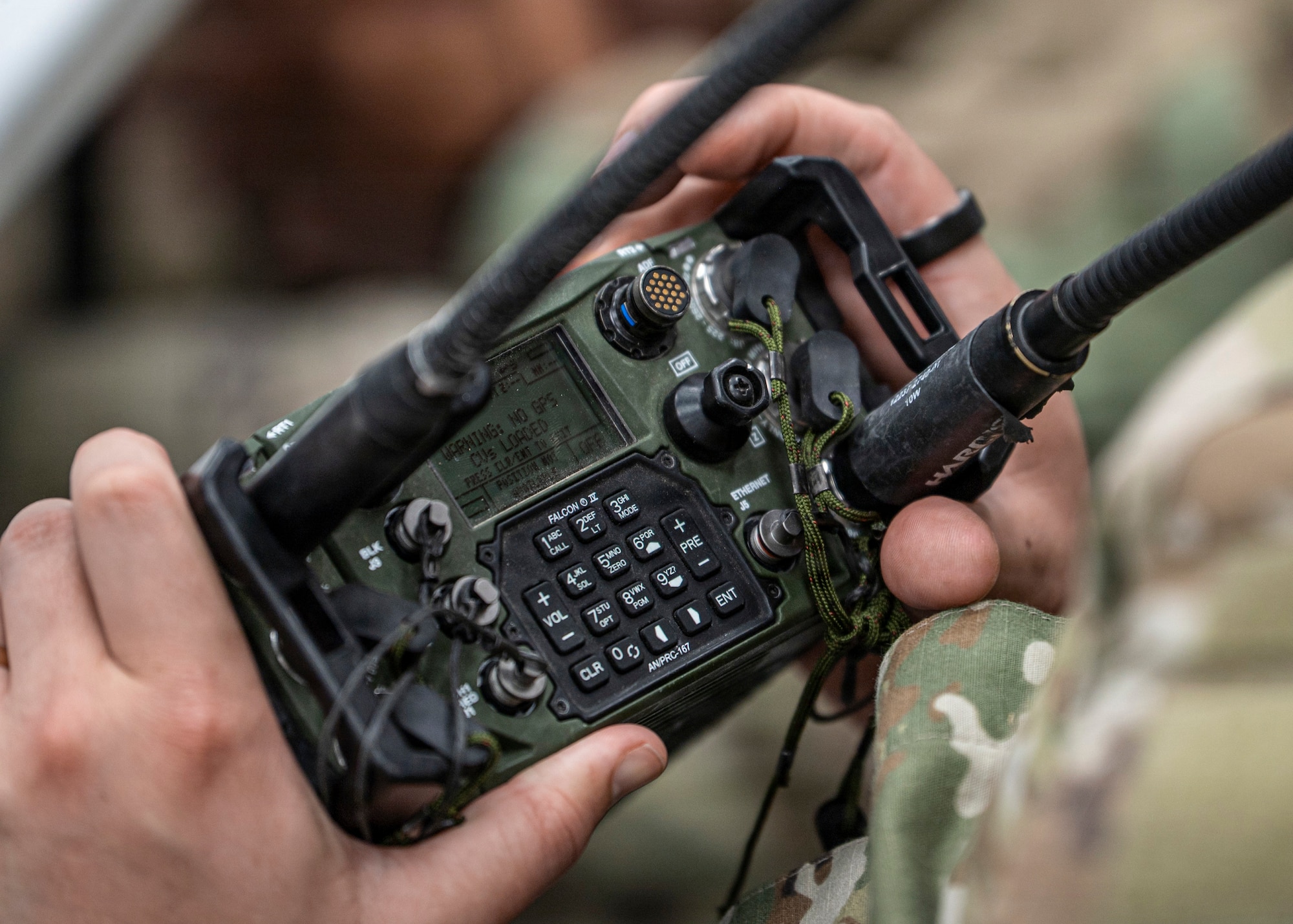 A U.S. Air Force Airman assigned to the 820th Base Defense Group inspects a British Armed Forces radio at Moody Air Force Base, Georgia, Jan. 15, 2026. The interaction gave Airmen the opportunity to learn about allied equipment and discuss communication techniques to strengthen joint operations. (U.S. Air Force photo by Senior Airman Leonid Soubbotine)