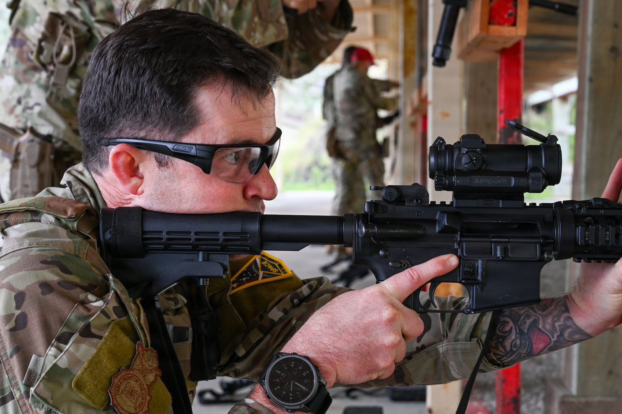 a man holds a rifle and looks down the sight