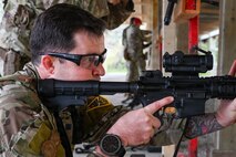 a man holds a rifle and looks down the sight