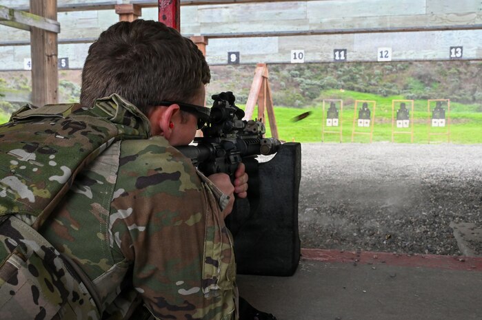 a person in a prone position fires a rifle down a firing range