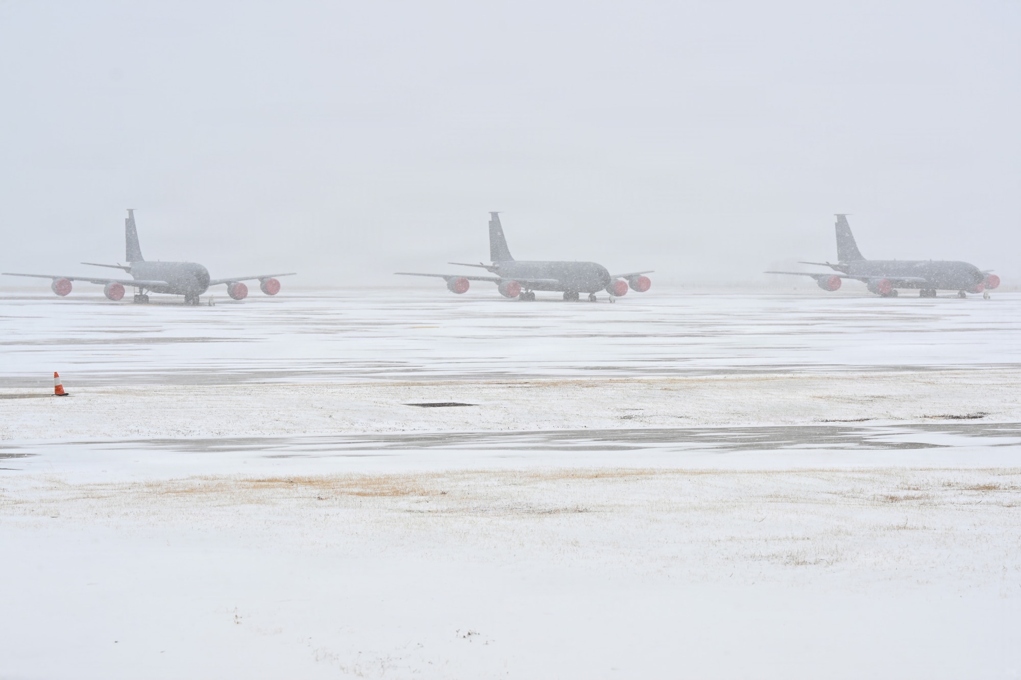Three KC-135 Stratotankers line the airfield during a snowstorm at McConnell Air Force Base, Kansas, Jan. 24, 2026. Aircraft remained parked as the airfield accumulated snow.  (U.S. Air Force photo by Senior Airman Amelio Brown)