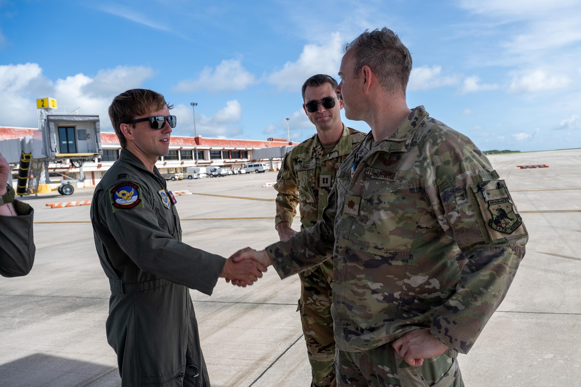 U.S. Air Force Captains Carter Sweat, left, and Pate Davis, center, pilots assigned to the 39th Airlift Squadron, are greeted by U.S Air Force Maj. Jacob Maynard, 14th Airlift Squadron C-17 instructor aircraft commander, prior to a community engagement event during Exercise Palmetto Reach at Saipan International Airport, Jan. 20, 2026. Palmetto Reach is a geographically separated, multi-faceted exercise hosted by the 14th AS aimed at bolstering cohesion within the force and gaining familiarity in the region. (U.S. Air Force photo by Airman 1st Class Adrien Tran)