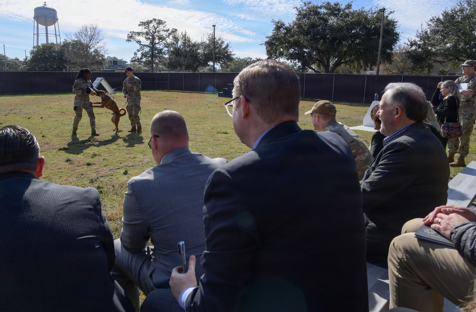 People watch from bleachers while a military working dog demonstration takes place.