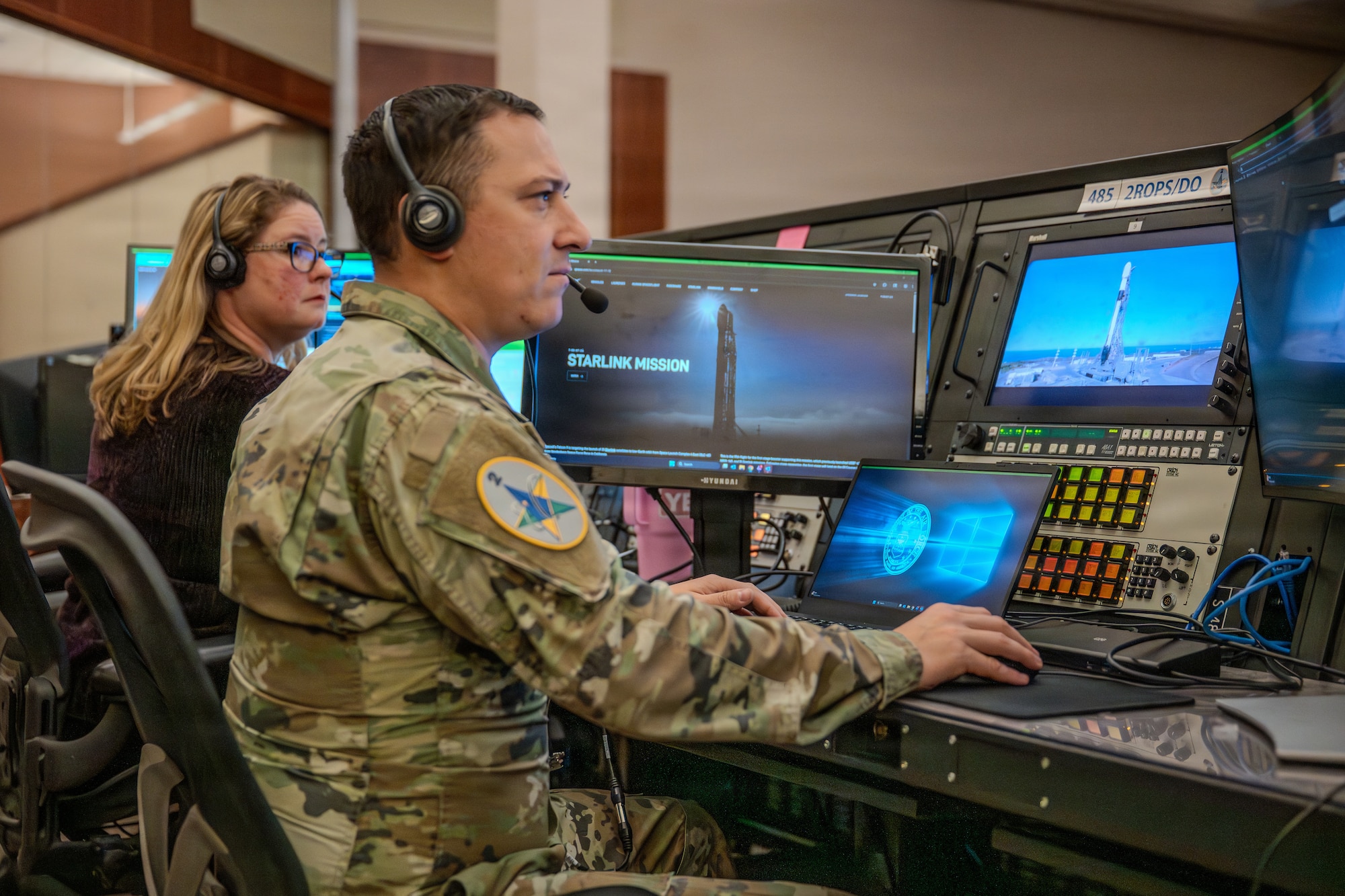 U.S. Space Force Maj. Christopher Menino, right side of photo, 2nd Range Operations Squadron deputy squadron commander, and Dawn Thomas, left side of photo, a range operations systems training engineer, monitor range data on computer screens.