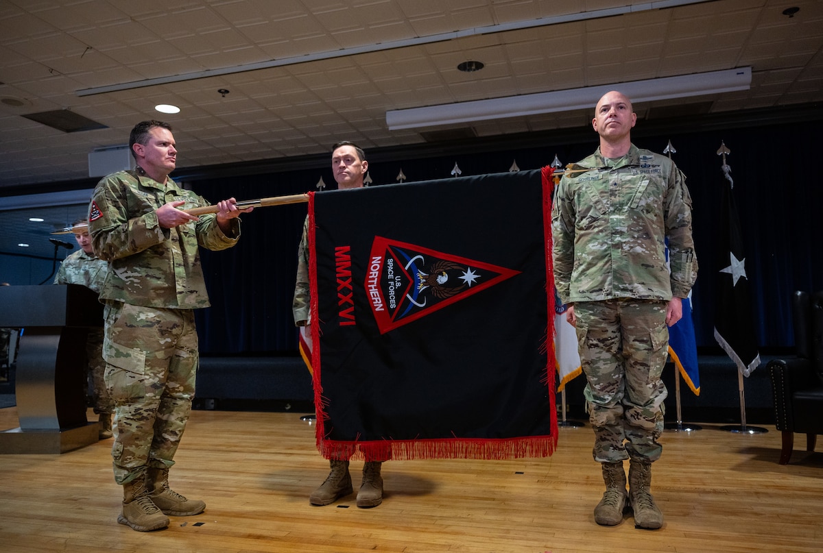 Chief Master Sergeant Seth Hogan, Command Senior Enlisted Leader Space Forces Northern unfurls the SPACEFOR-NORTH guidon during the SPACEFOR-NORTH activation ceremony at Peterson SFB, Colo., Jan 30, 2026. U.S. Space Forces Northern, serves as the Space Force service component to U.S. Northern Command. (U.S. Space Force photo by John Ayre)