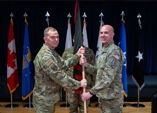 Gen. Gregory Guillot, North American Aerospace Defense Command and U.S. Northern Command commander passes the guidon emblazoned with the Space Forces-Northern emblem to Brig. Gen. Robert Schreiner, SPACEFOR-NORTH commander during the SPACEFOR-NORTH activation ceremony at Peterson SFB, Colo., Jan 30, 2026. U.S. Space Forces Northern, serves as the Space Force service component to U.S. Northern Command. (U.S. Space Force photo by John Ayre)