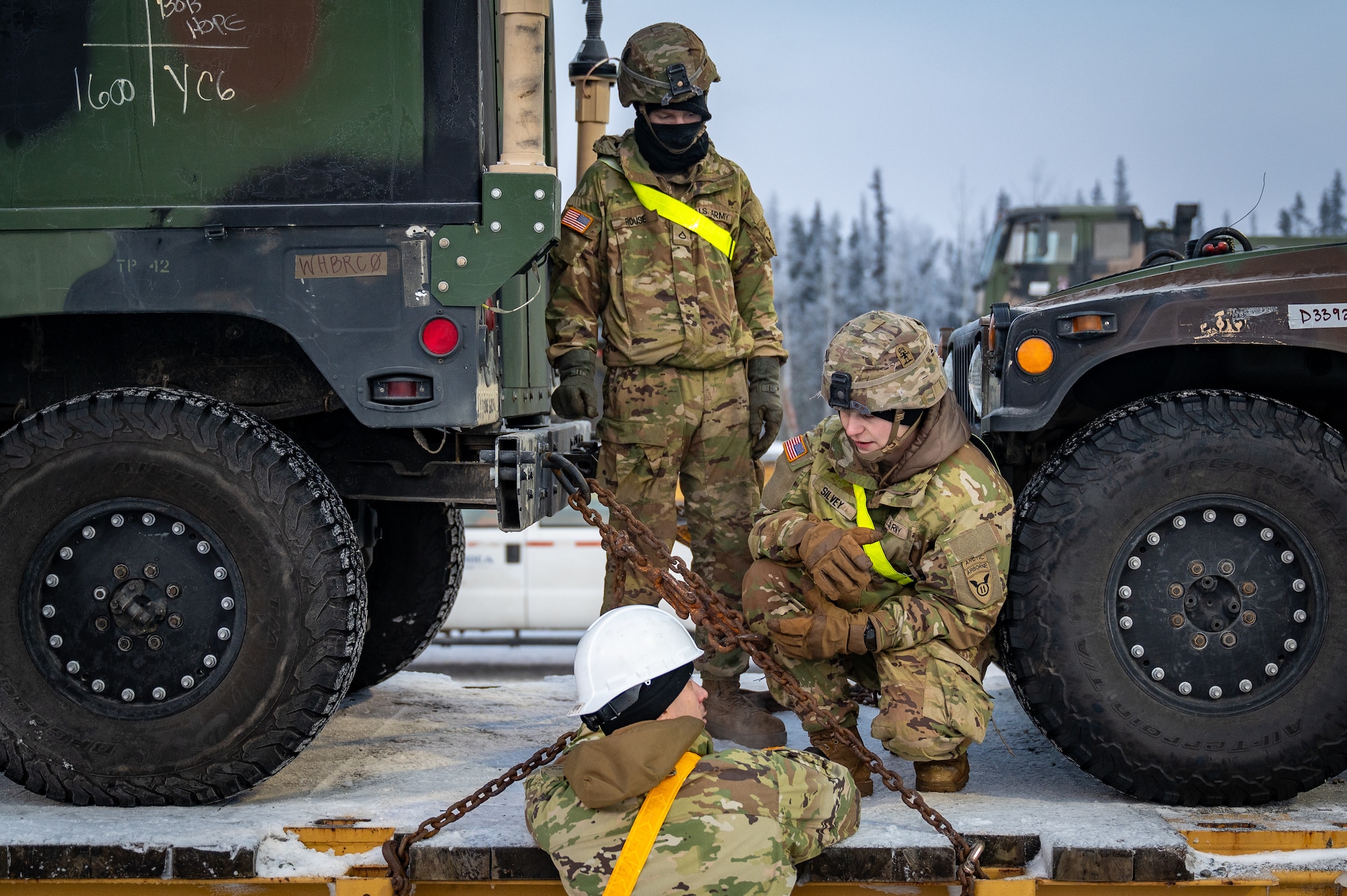 U.S. Army Soldiers assigned to the 3rd Battalion, 509th Parachute Infantry Regiment, 11th Airborne Division, secure vehicles on a flatcar at Joint Base Elmendorf-Richardson, Alaska, Jan. 22, 2026, in preparation for Joint Pacific Multinational Readiness Center 26-02. Rail loading enables the rapid movement of personnel and equipment, ensuring unit readiness and the ability to deploy efficiently for large-scale training exercises. (U.S. Air Force photo by Senior Airman Hunter Hites)