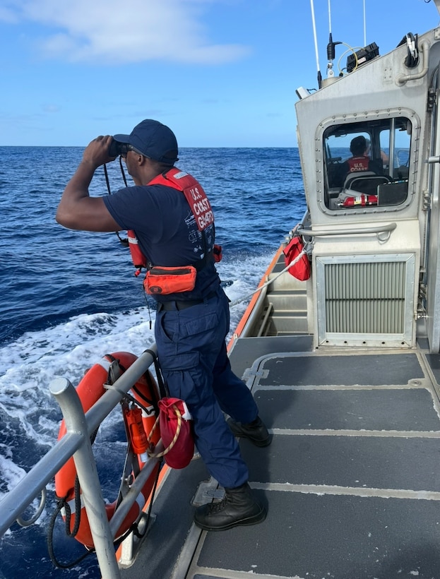 U.S. Coast Guard Seaman Marquis Turner, a deck department member assigned to Coast Guard Station Kauai in Lihue, Hawaii, uses binoculars to search for a man in the water off the north shore of Kauai Jan. 30, 2026. Coast Guard and agency partners are searching for a man in the water who was swept off the rocks while fishing near Kahili Beach. (U.S. Coast Guard photo, courtesy Station Kauai)