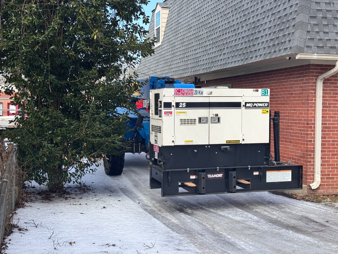 a forklift carries a generator down a snow covered path.