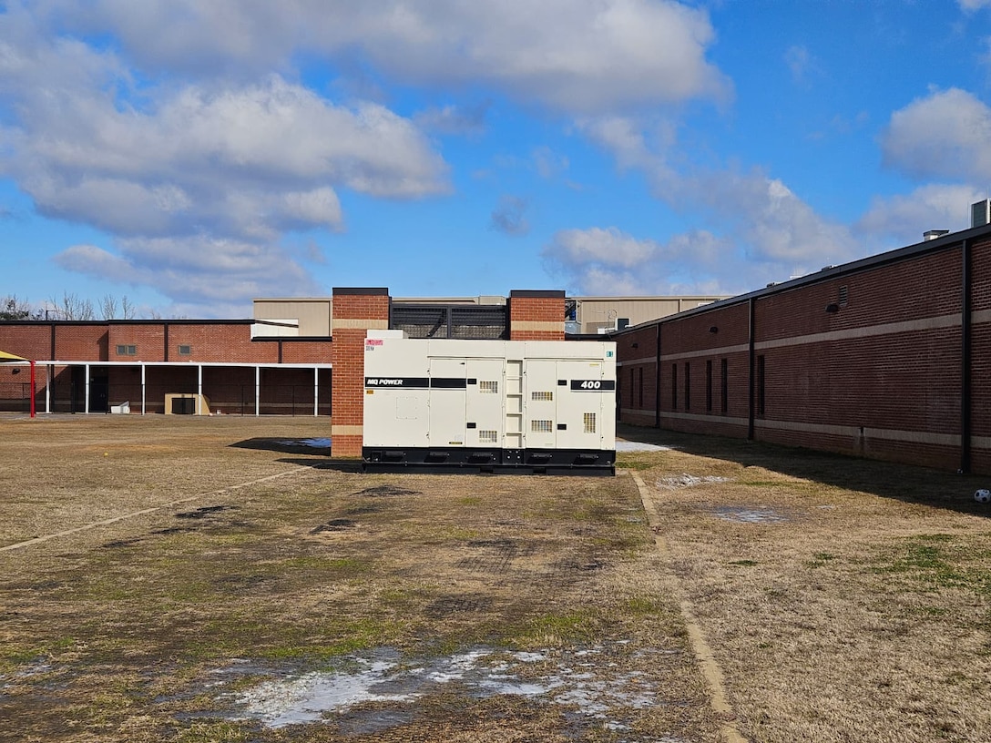 a large generator sits next to a school.
