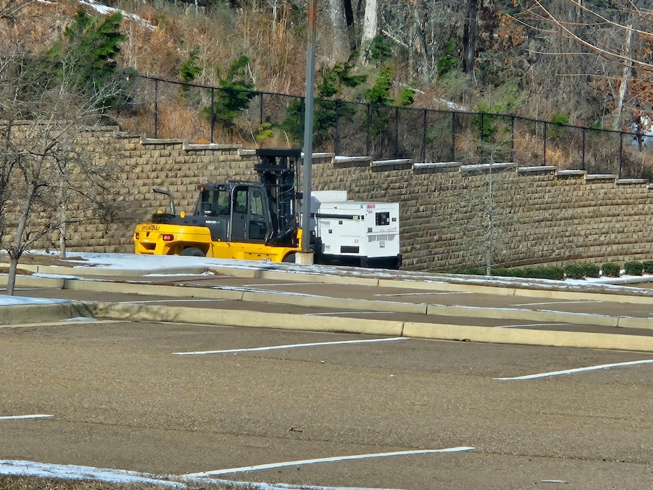A forklift transports a large generator