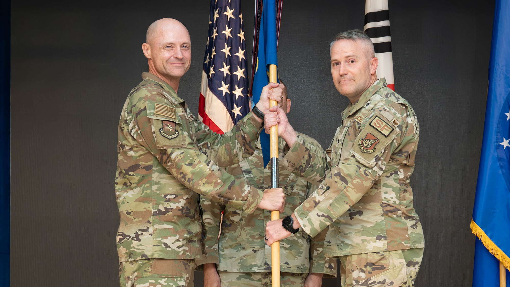 U.S. Air Force Lt. Col. Shane Watts, right, incoming 51st Security Forces Squadron commander, accepts command of the 51st SFS from Col. Jeff Elliott, 51st Mission Support Group commander, during a change of command ceremony at Osan Air Base, Republic of Korea, June 26, 2026. The 51st SFS is the largest Security Forces unit in the Pacific Air Forces, defending and guarding more than $18 billion dollars in Protection level 1 through 4 resources and over 13,000 personnel. (U.S. Air Force photo by Senior Airman Megan Cusmano)