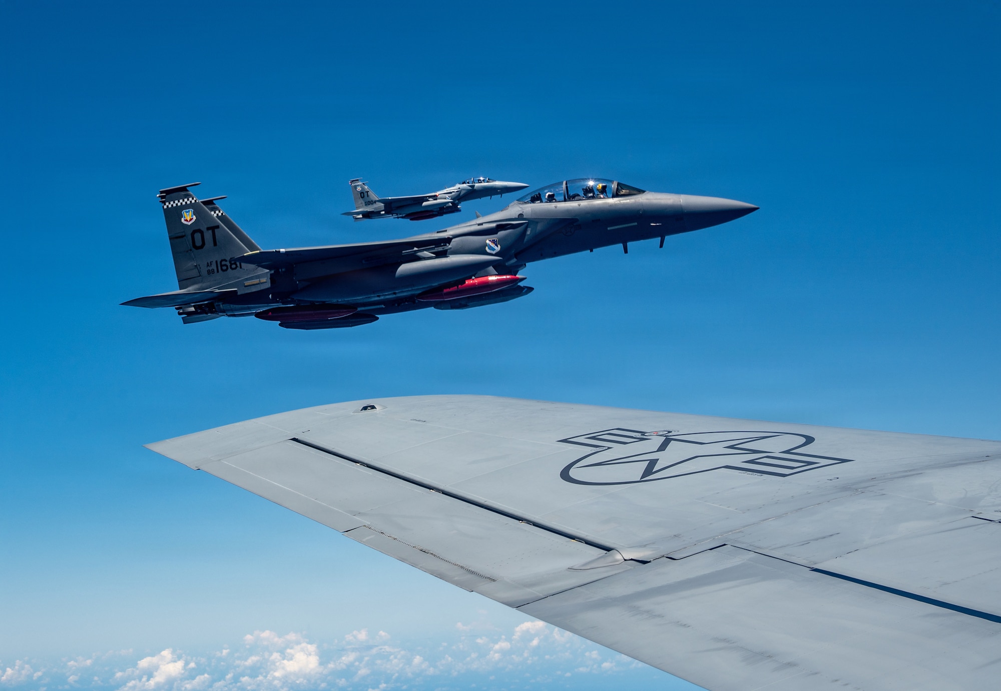 A U.S. Air Force F-15EX Eagle II and F-15E Strike Eagle assigned to the 85th Test and Evaluation Squadron, Eglin Air Force Base, Florida, fly in formation on the wing of a KC-135 Stratotanker assigned to the 909th Air Refueling Squadron over the Pacific Ocean, June 29, 2026.
