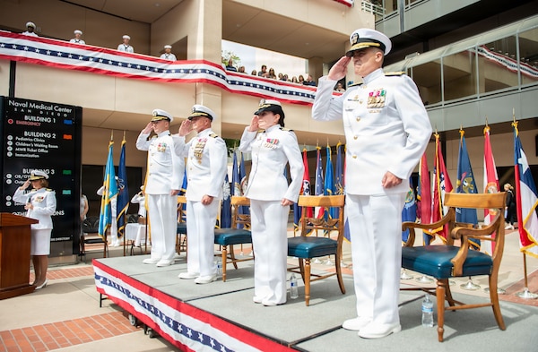 The official party for the Navy Medicine Readiness and Training Command (NMRTC) San Diego change of command and Naval Medical Center San Diego (NMCSD) transfer of directorship ceremony renders honors during the parading of the colors at NMCSD, June 30, 2026. NMRTC San Diego supports Navy and Marine Corps readiness by ensuring its medical forces are ready to deploy and provide medical support, ashore or at sea. The mission of NMCSD is to optimize health and enhance readiness. NMCSD employs more than 5,500 active-duty military personnel, civilians, and contractors in southern California to deliver exceptional care afloat and ashore. (U.S. Navy photo by Mass Communication Specialist 1st Class Marcus Stanley)