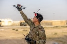 A U.S. Army paratrooper prepares to launch an unmanned aerial system (UAS) in the Middle East during a routine training event. Small UAS platforms provide units with real-time aerial observation capabilities that assist with reconnaissance, security, and terrain analysis. (U.S. Army photo)