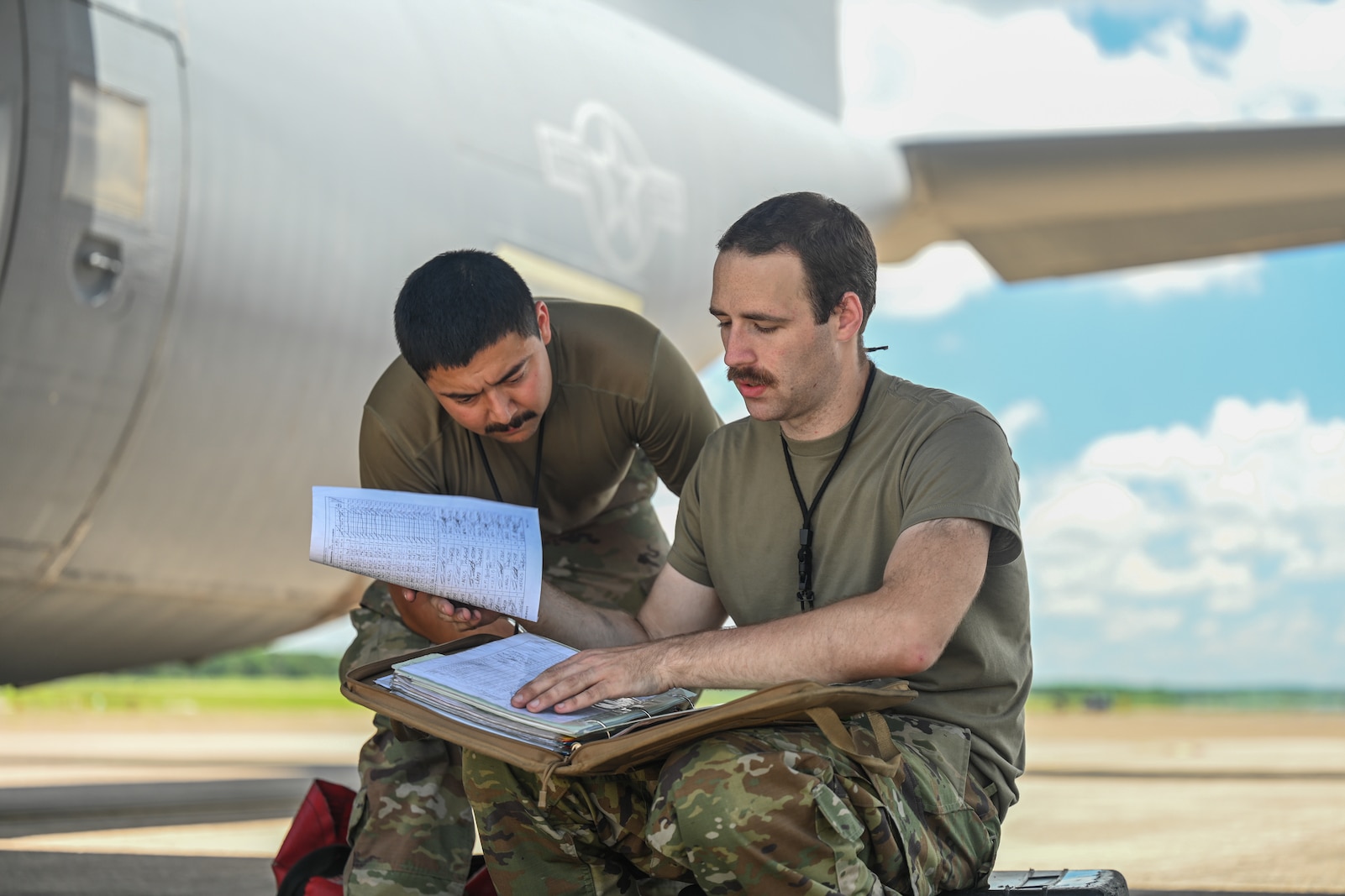 Airmen look through a folder.