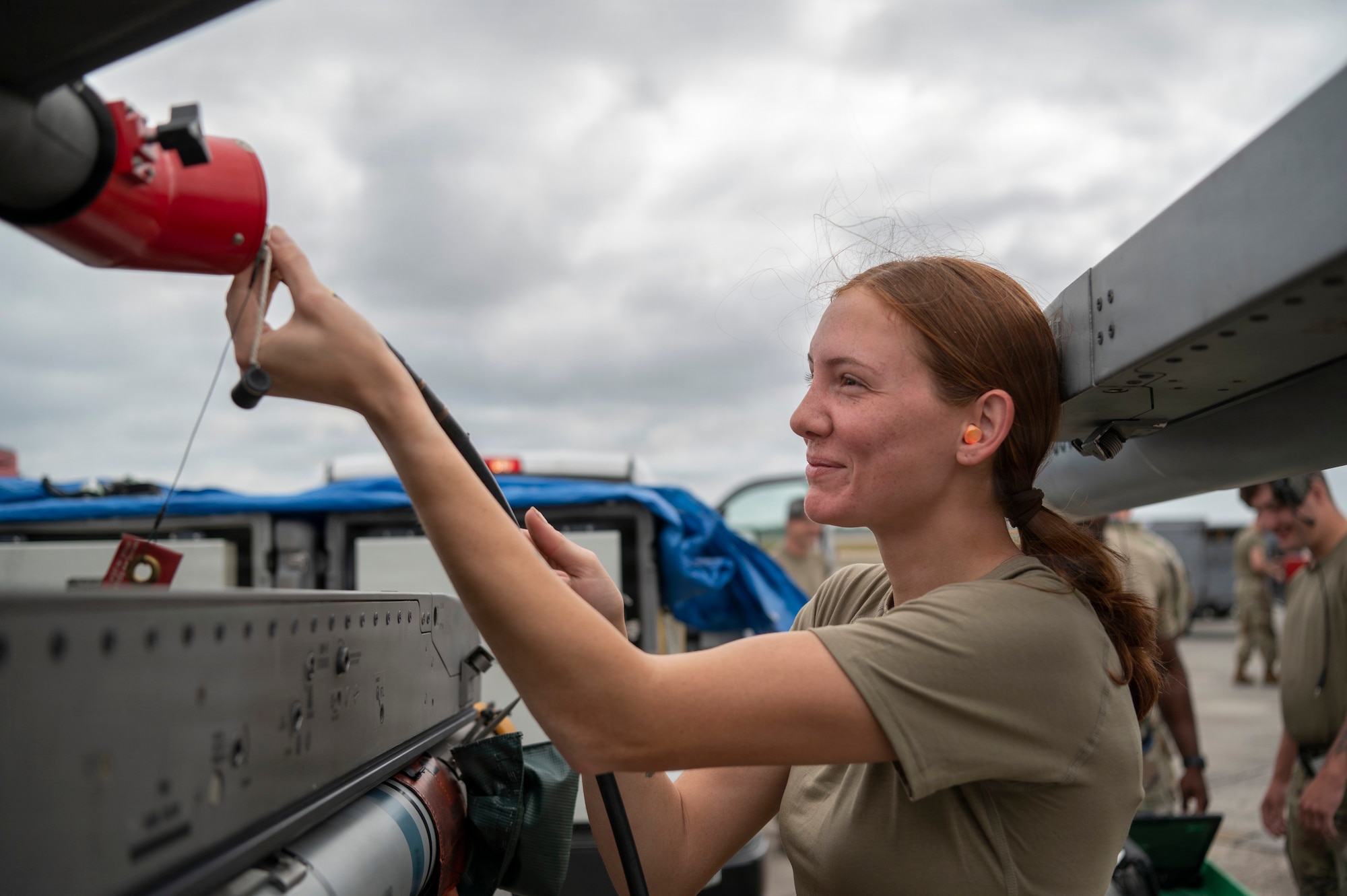 woman does maintenance on a fighter jet